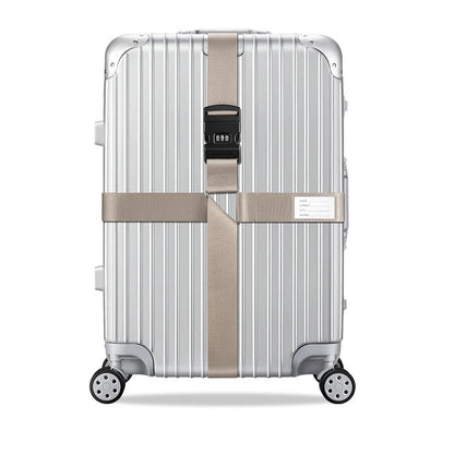 Sangle pour valise croisée antivol à code fixée sur une valise rigide argent, utilisée en situation réelle dans un aéroport, avec poignée télescopique tirée par un voyageur. khaki