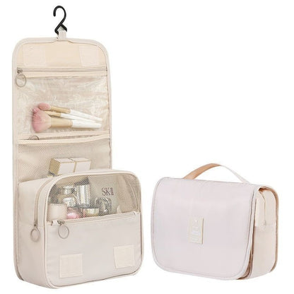 trousse de toilette voyage beige  a crochet avec compartiments multiples suspendue ouverte organisation produits toilette bagage cabine avion