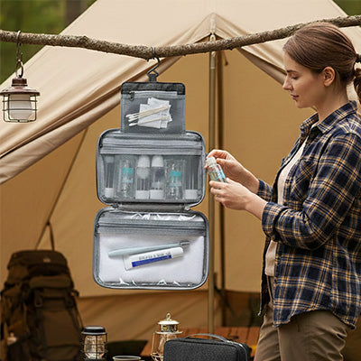 Trousse de toilette suspendue rose pour voyage et camping, avec plusieurs compartiments pour produits de soin et maquillage.