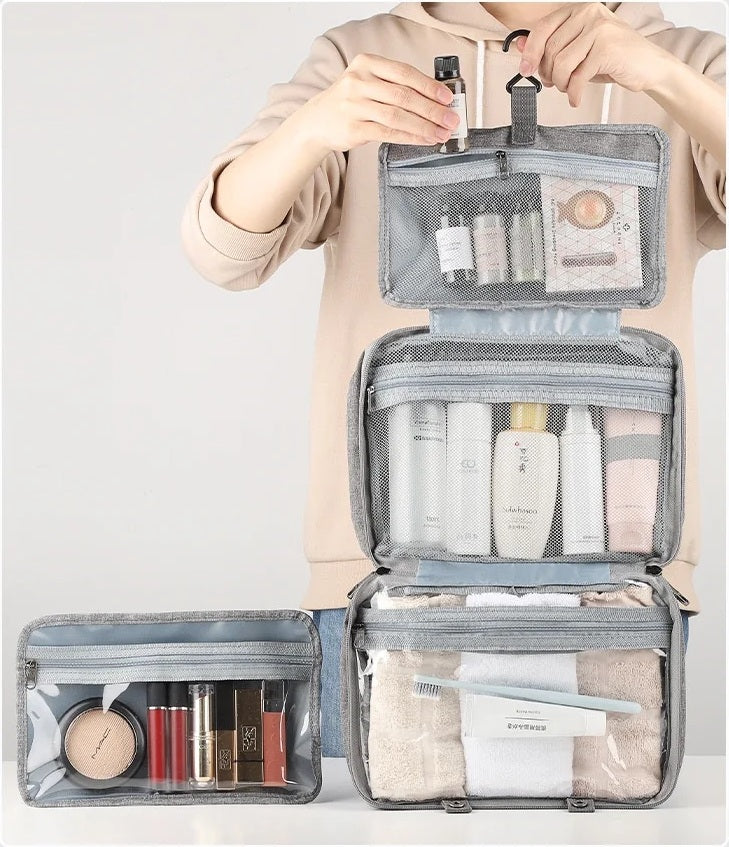 Trousse de toilette de voyage grise pliable avec poignée, compacte et élégante pour organiser ses produits de toilette en déplacement.